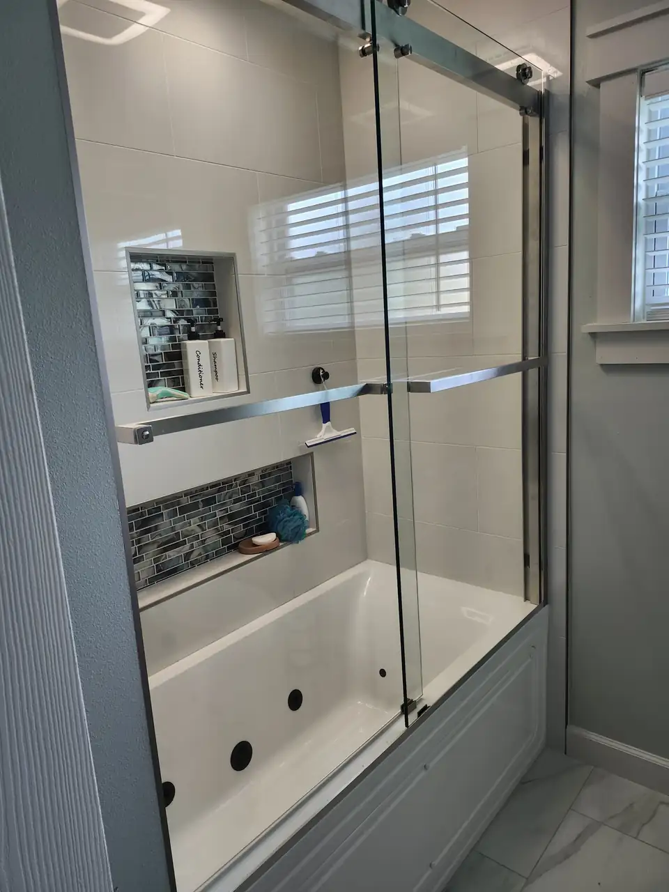 Tub and shower with sliding glass doors, white tile and a glass mosaic niche, bathroom remodeling Titusville
