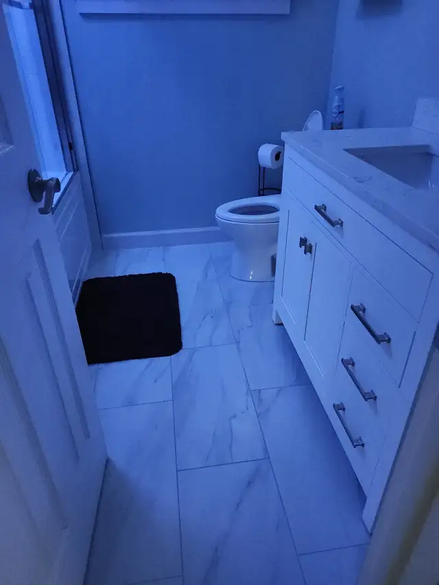 Bathroom with white shaker vanity, marble-look floor tile and toilet